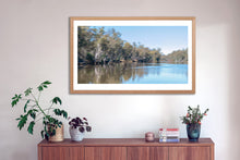 Load image into Gallery viewer, This Panoramic fine art photograph of a black swan on Murray River includes camera movement to creat and Impressionist style. The fine art print comes with three frames options: Oak, white or black. Or choose the “unframed” option to mount in your own frame.
